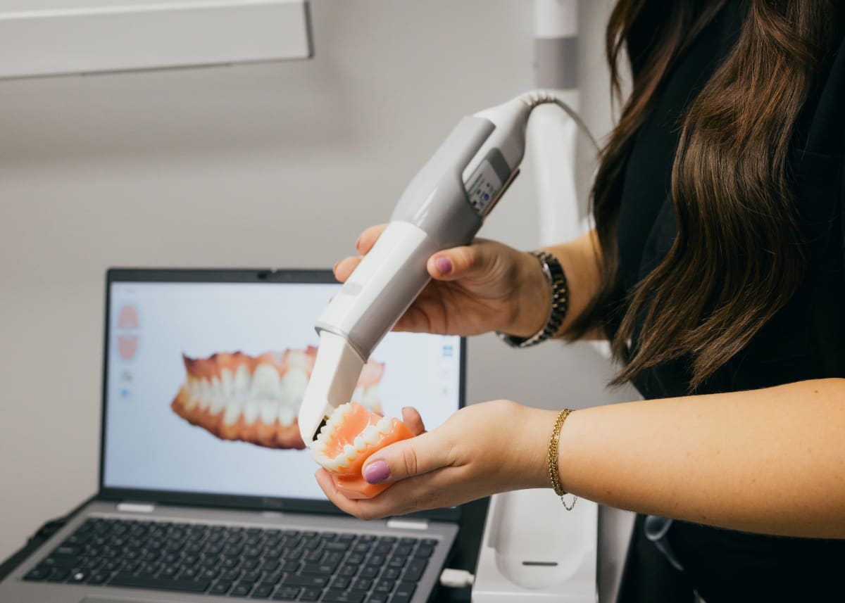Dentist demonstrating dental implant model to patient during consultation