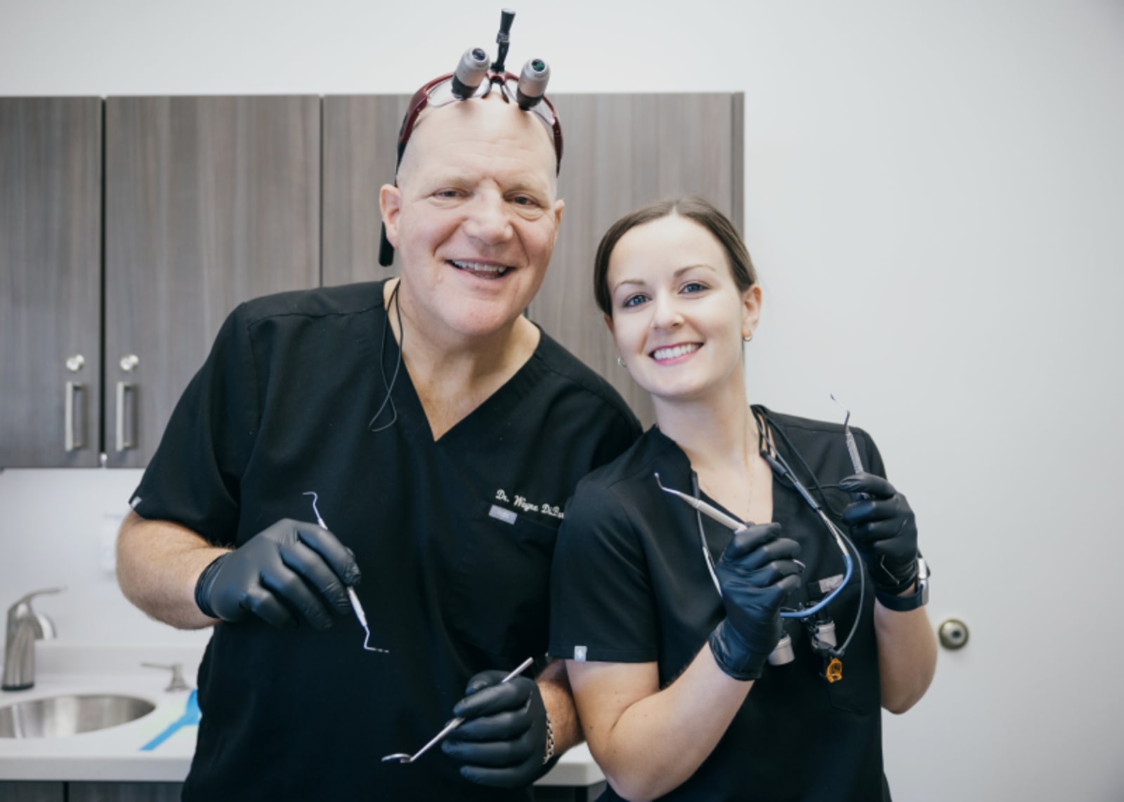 Two dental team members smiling together in treatment room