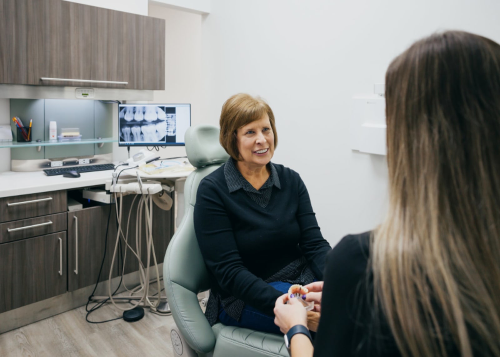 Female dentist discussing treatment plan with patient in clinical setting