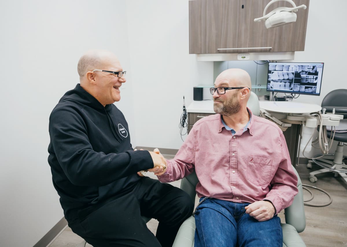 Dentist in consultation with patient in treatment room during dental procedure
