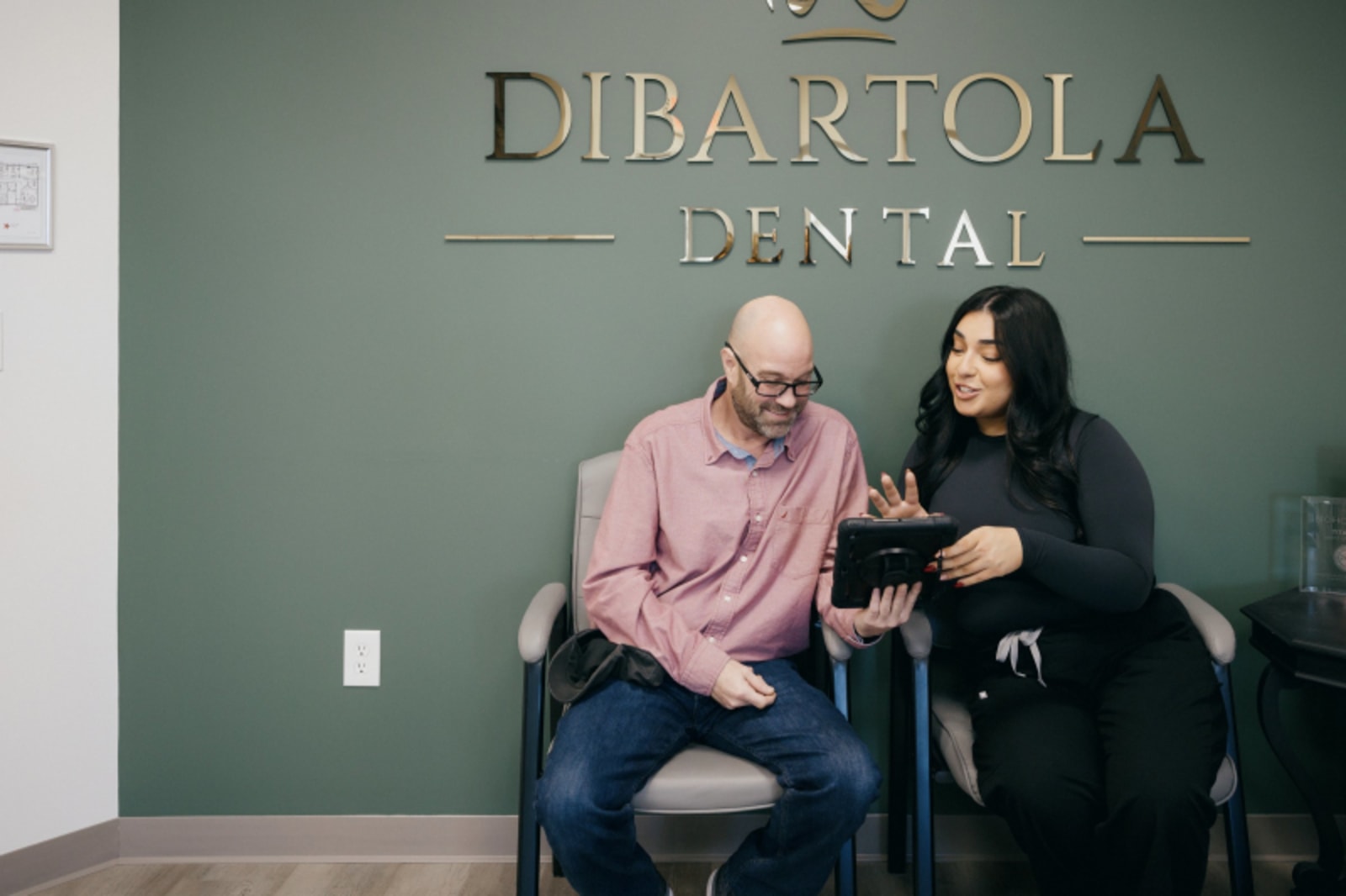Male dentist and female staff member standing together in DiBartola Dental office