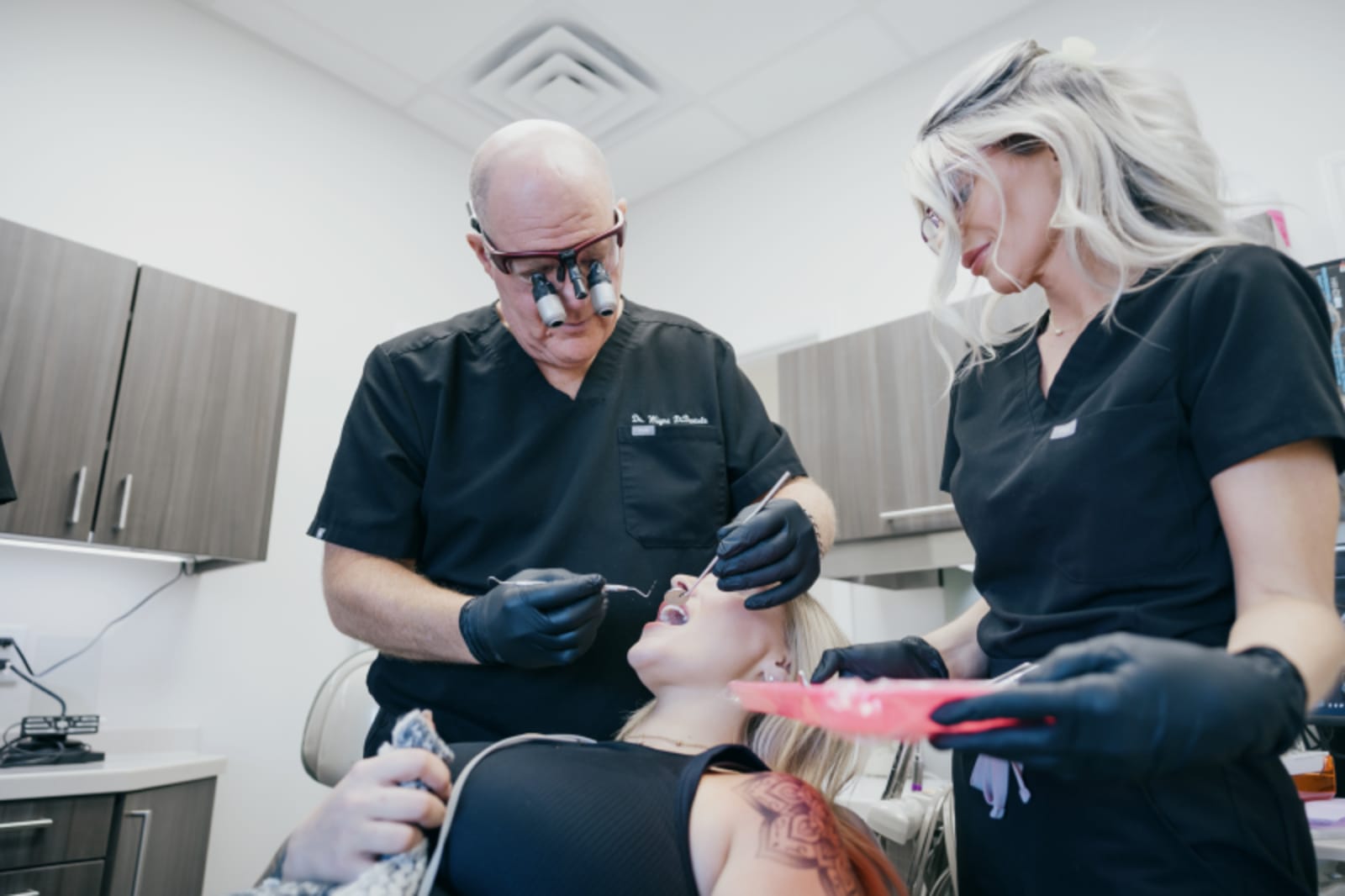 Dentist and dental assistant working together on patient in treatment room