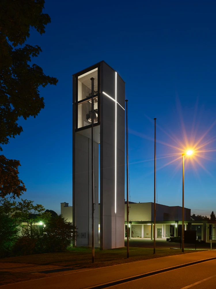 Low-angle drone view of the illuminated church tower architecture in Dietlikon, Switzerland