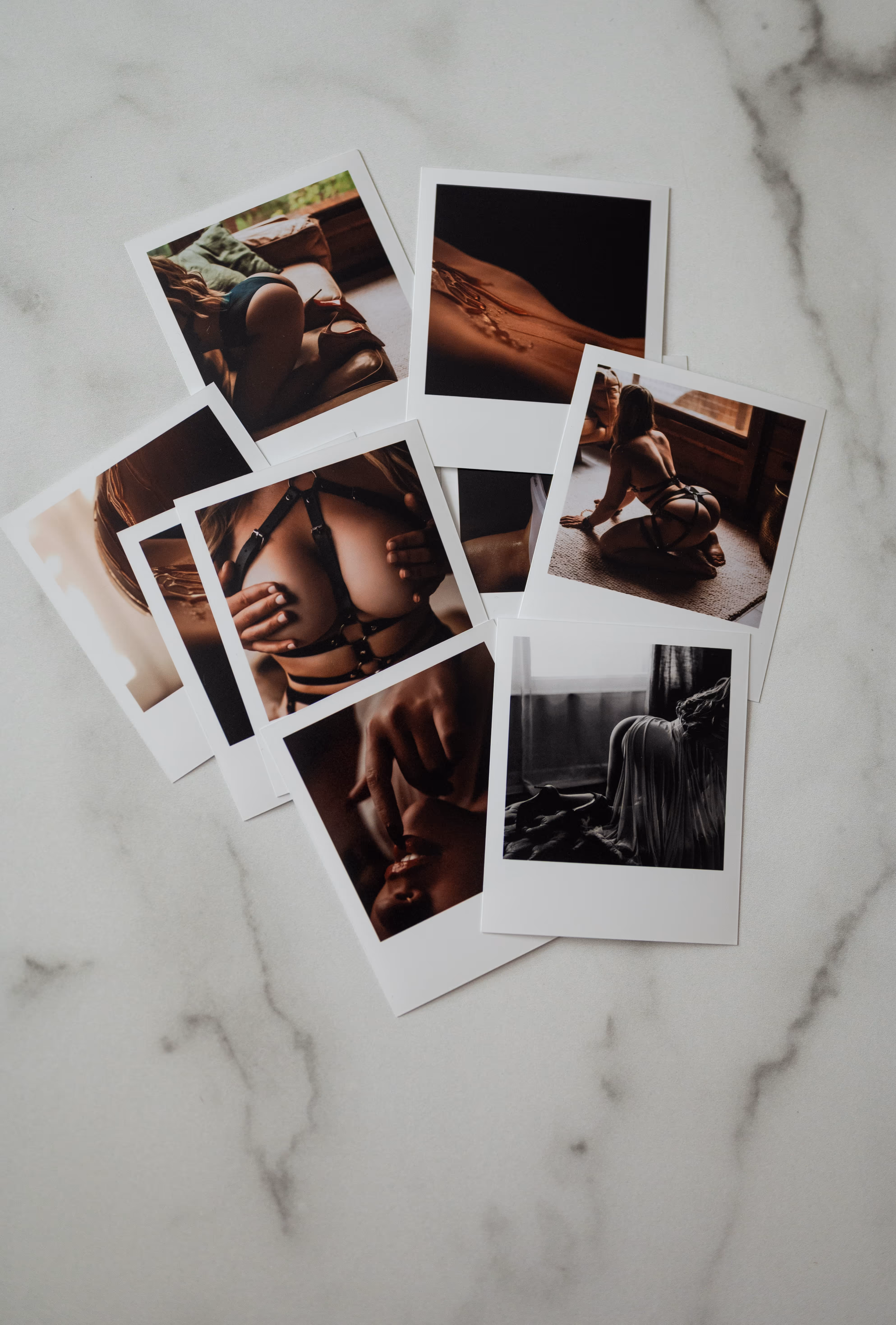 A collection of Polaroid-style photos featuring artistic boudoir images of a woman in lingerie and harnesses on a marble surface.