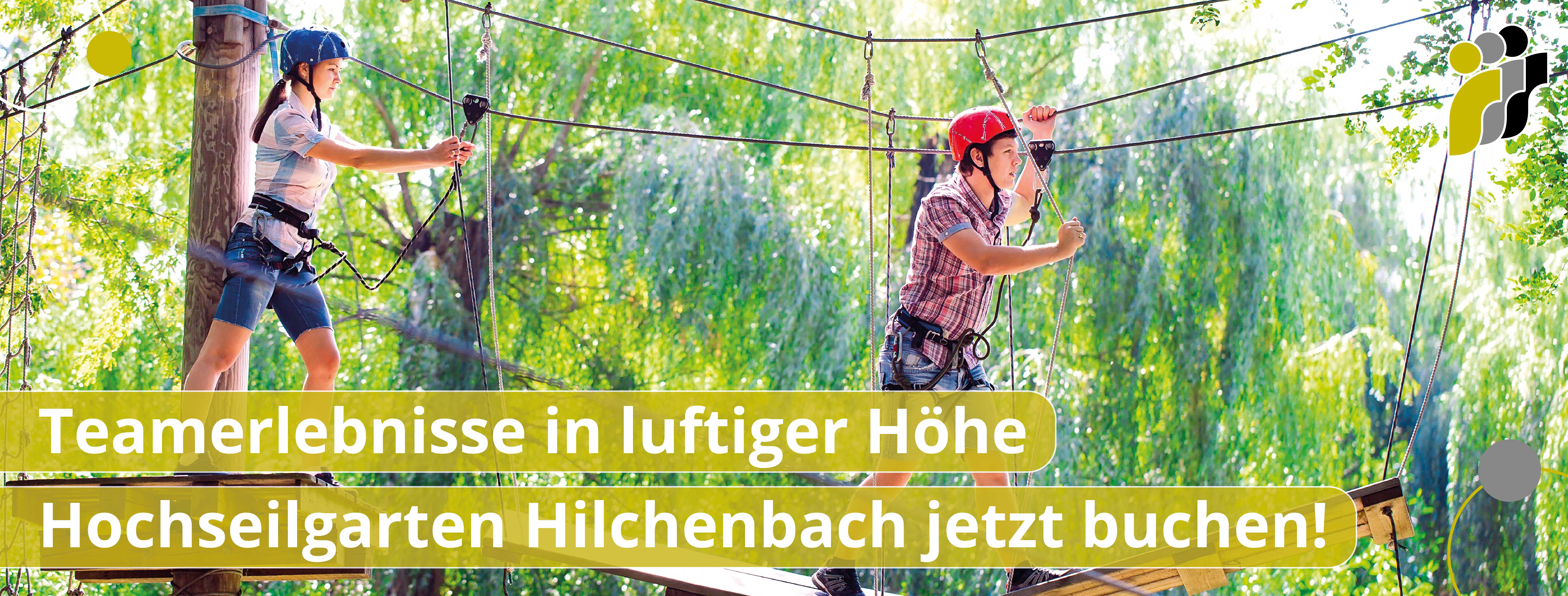 Zwei Personen mit Helmen und Sicherheitsgurten balancieren in einem Hochseilgarten zwischen Baumstämmen und Seilen. Mit dem Text Teamerlebnisse in luftiger Höhe Hochseilgarten Hilchenbach jetzt buchen