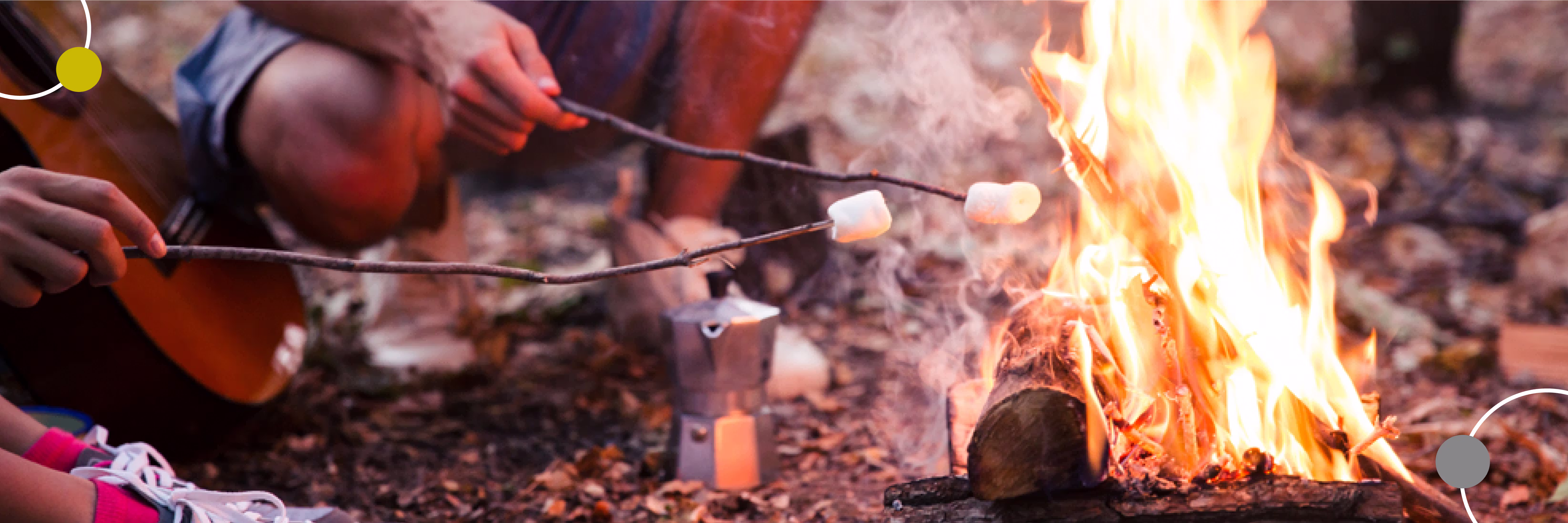 Zwei Menschen rösten Marshmallows über einem offenen Lagerfeuer im Freien.