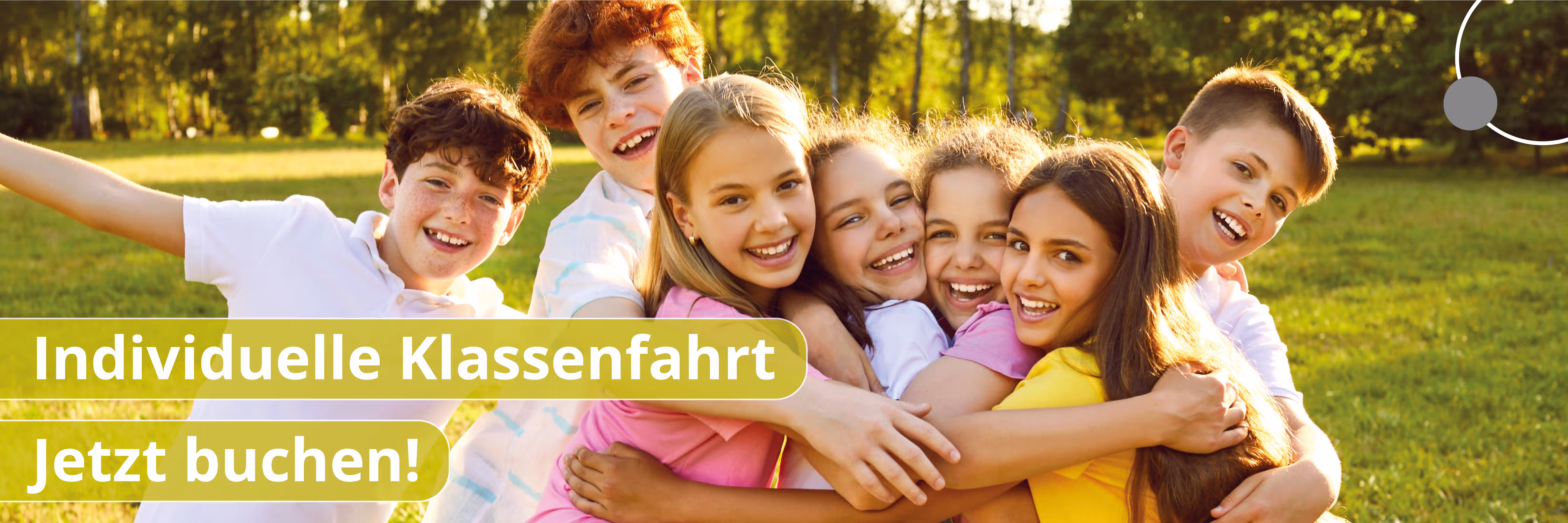 Gruppe lachender Kinder, die sich umarmen auf einer sonnigen Wiese im Park.