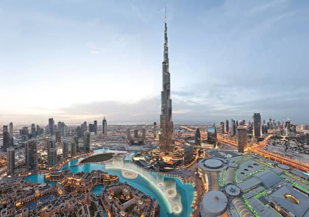 Yacht sailing past the Dubai skyline at sunset