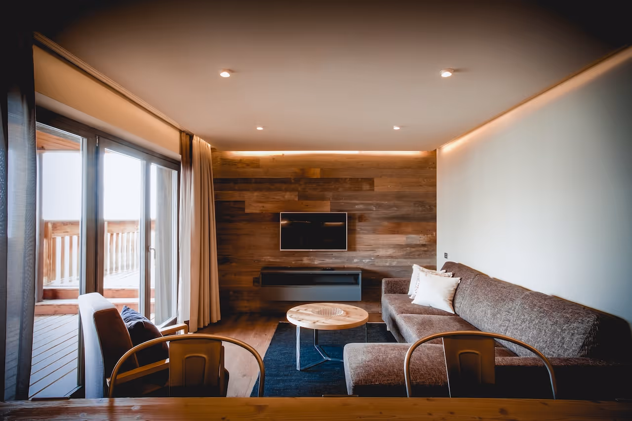 Ruime leefruimte met een gezellige bank, houten accenten en een flatscreen-tv.
