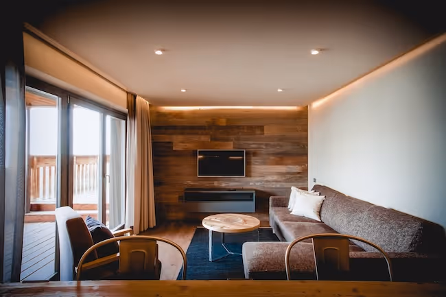 Ruime leefruimte met een gezellige bank, houten accenten en een flatscreen-tv.