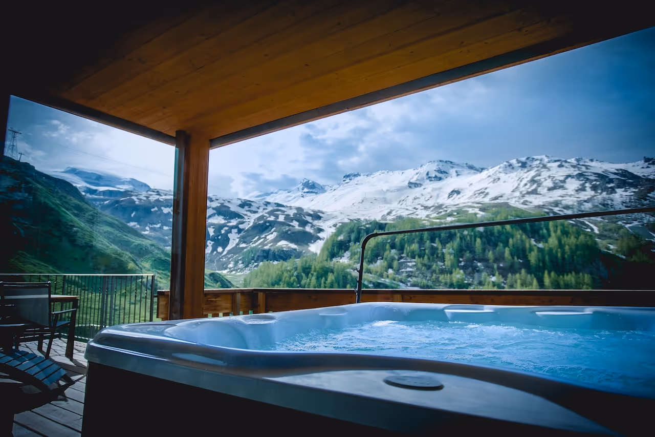 View from the hot tub to a cozy bedroom with warm wooden decor and snowflake-patterned bedding.