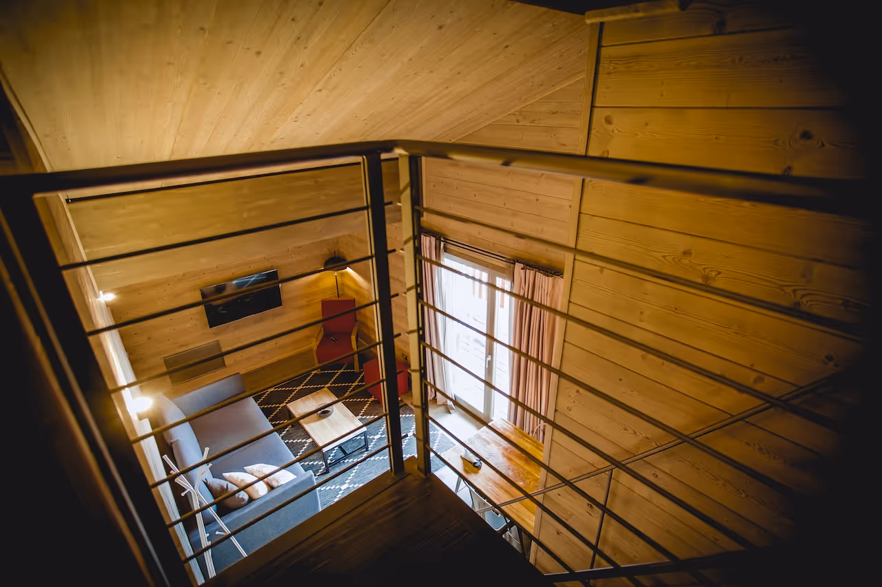 Overview of the Loft Suite living room with wooden interiors and stylish furniture at La Cresta.