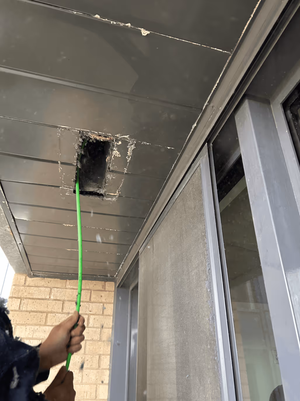 Technician working on a wall-mounted heat pump.