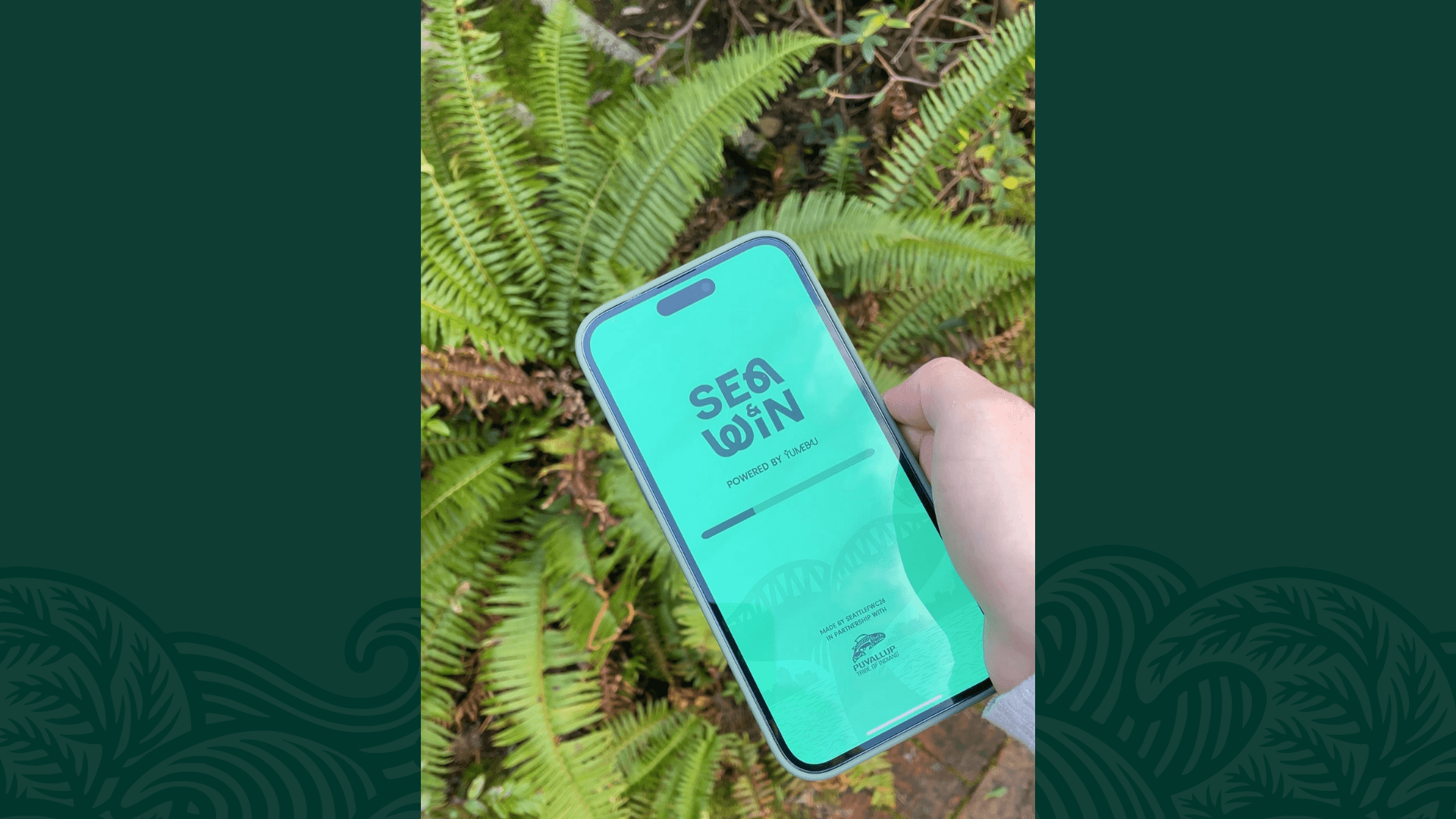 A hand holds a smartphone displaying the "SEA&WIN POWERED BY YUMEBAU" teal loading screen, set against a background of bright green ferns.