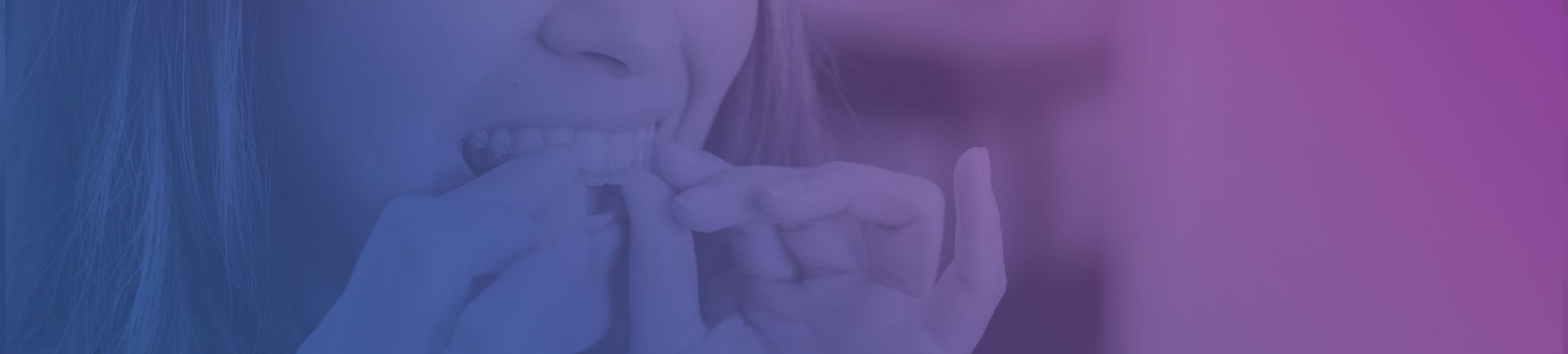 Person adjusting clear dental aligners with a gentle smile