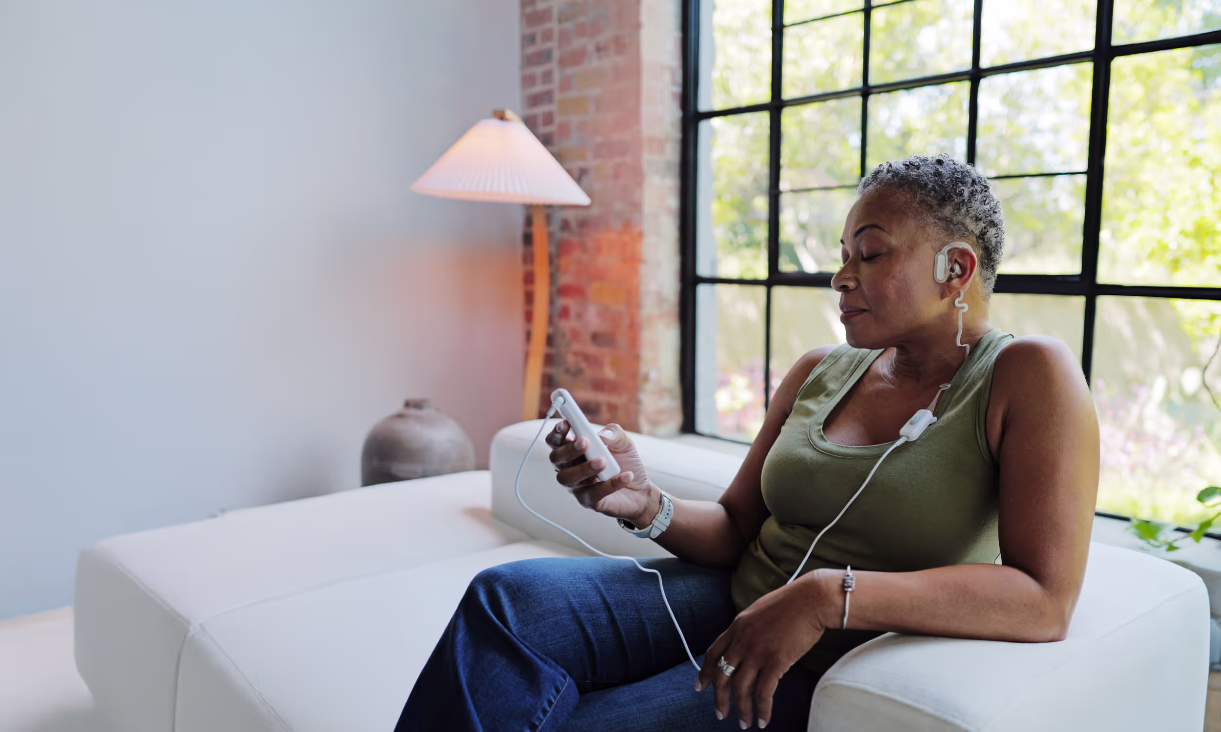 Woman relaxing on couch using Spark Biomedical's Sparrow Ascent