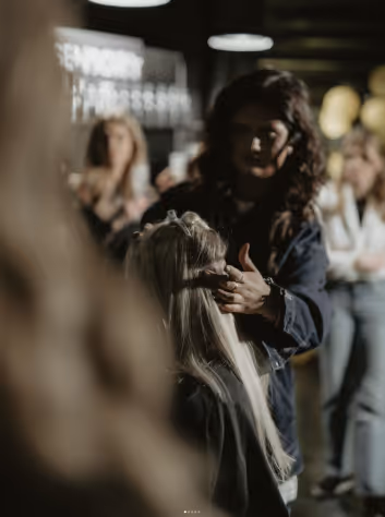 En frisör sätter i hair extensions på en kund