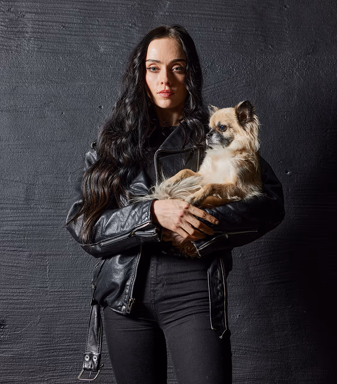 Ung kvinna med Sensory Value-Extensions och en liten hund i famnen.