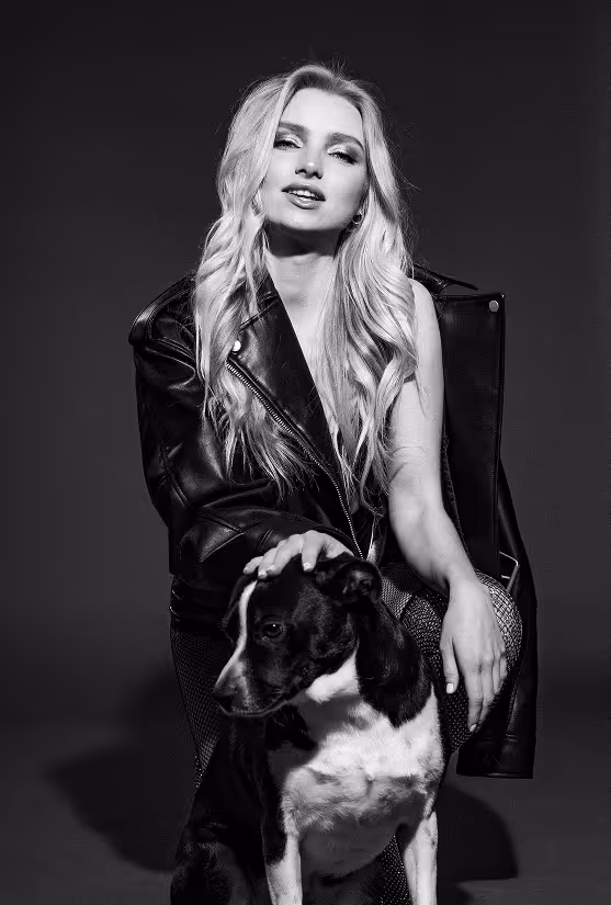 Kvinna sitter på huk tillsammans med en hund.