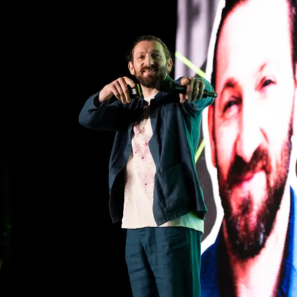 A man standing in front of a picture of a man.