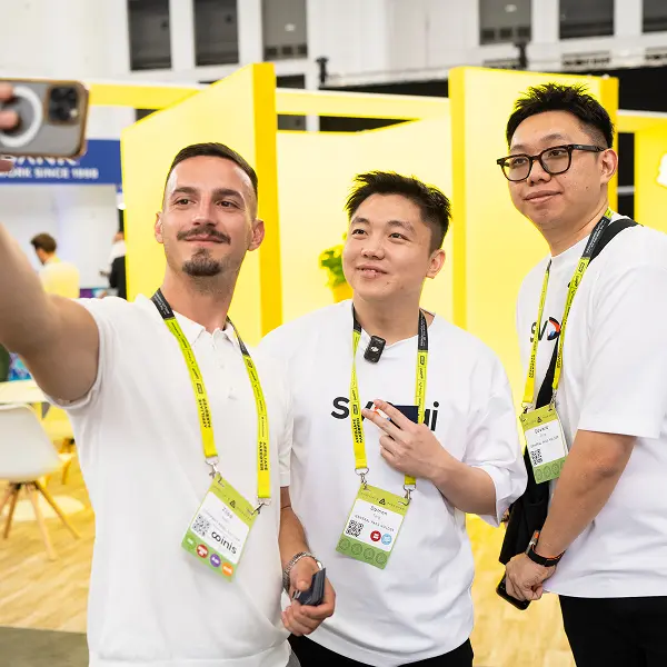Three men taking a picture with a cell phone.