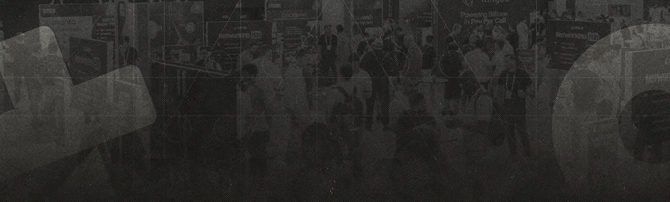 Crowded exhibition hall with multiple booths and attendees engaging in conversations.