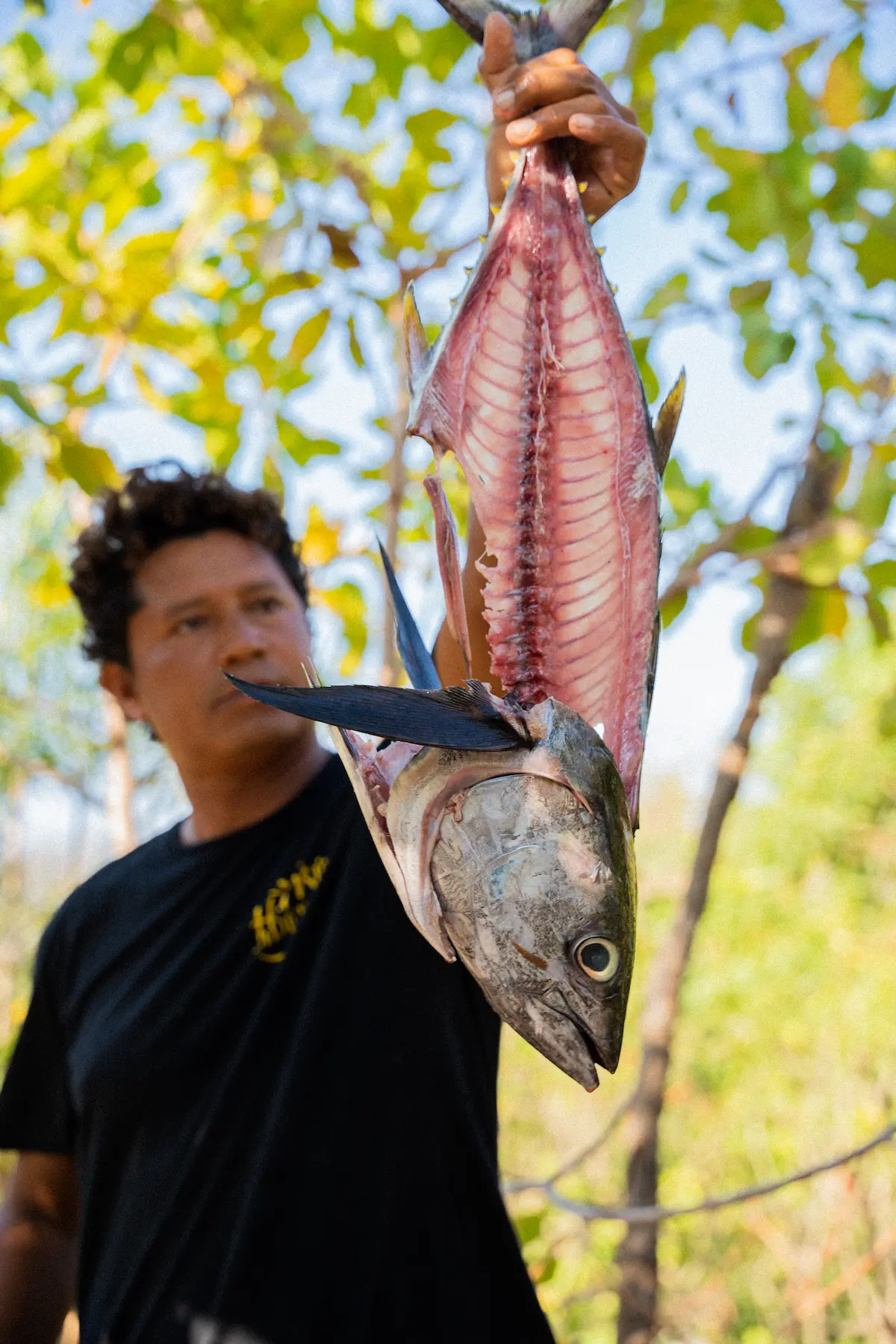 A man holding a filleted fish. 