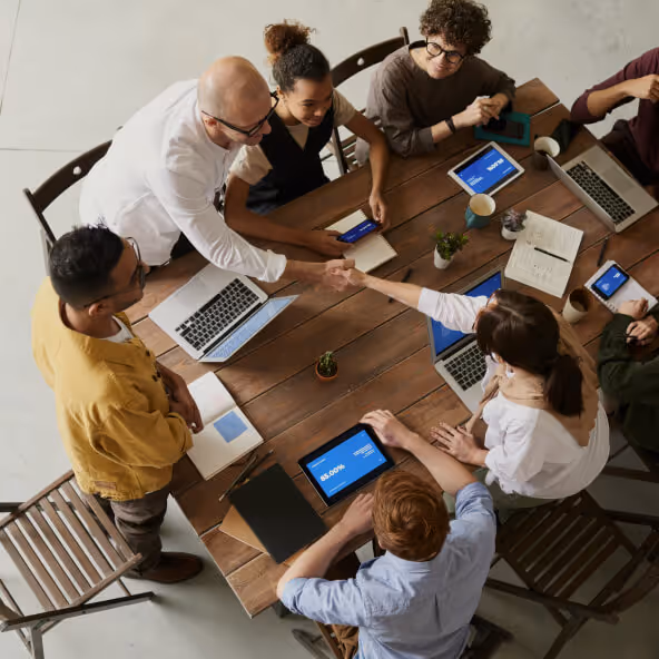 A group of people around a table with laptops