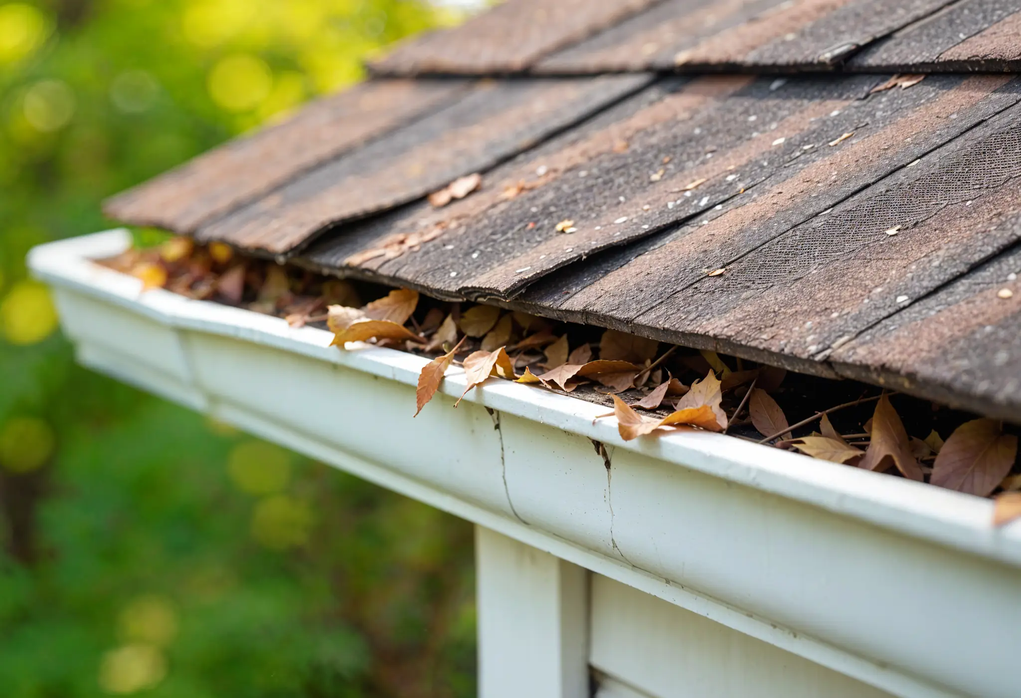 an ultra-realistic photo of roof with missing shingles and clogged gutters