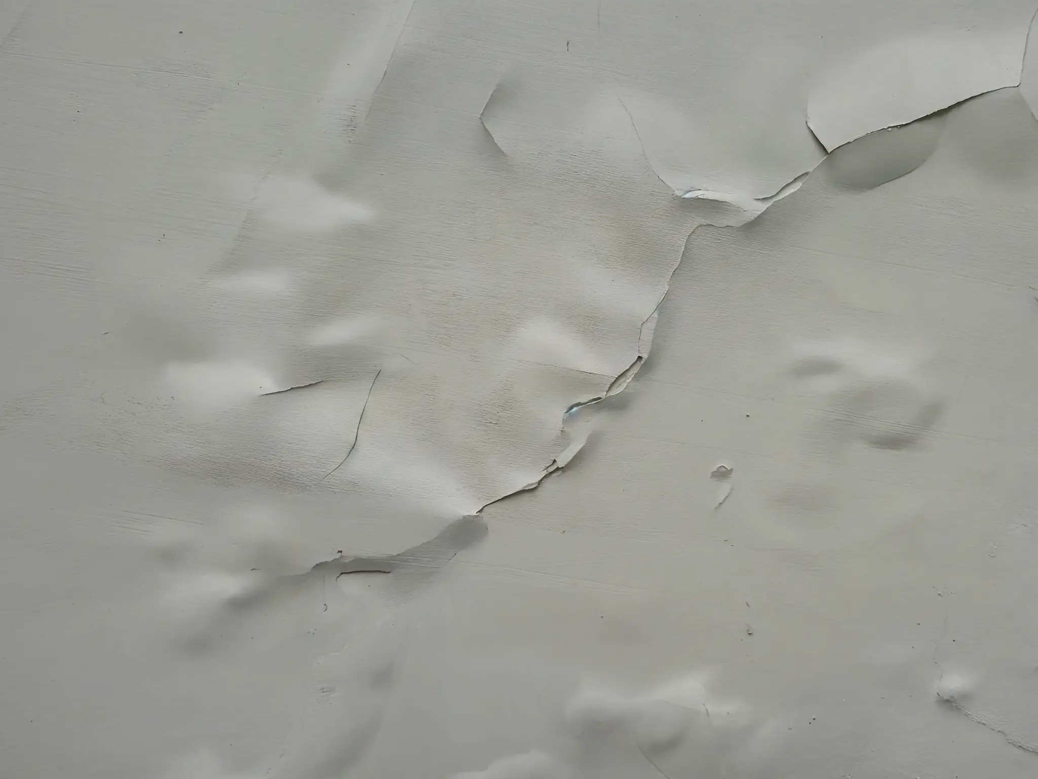 paint bubbles and peeling on wall from roof moisture problem