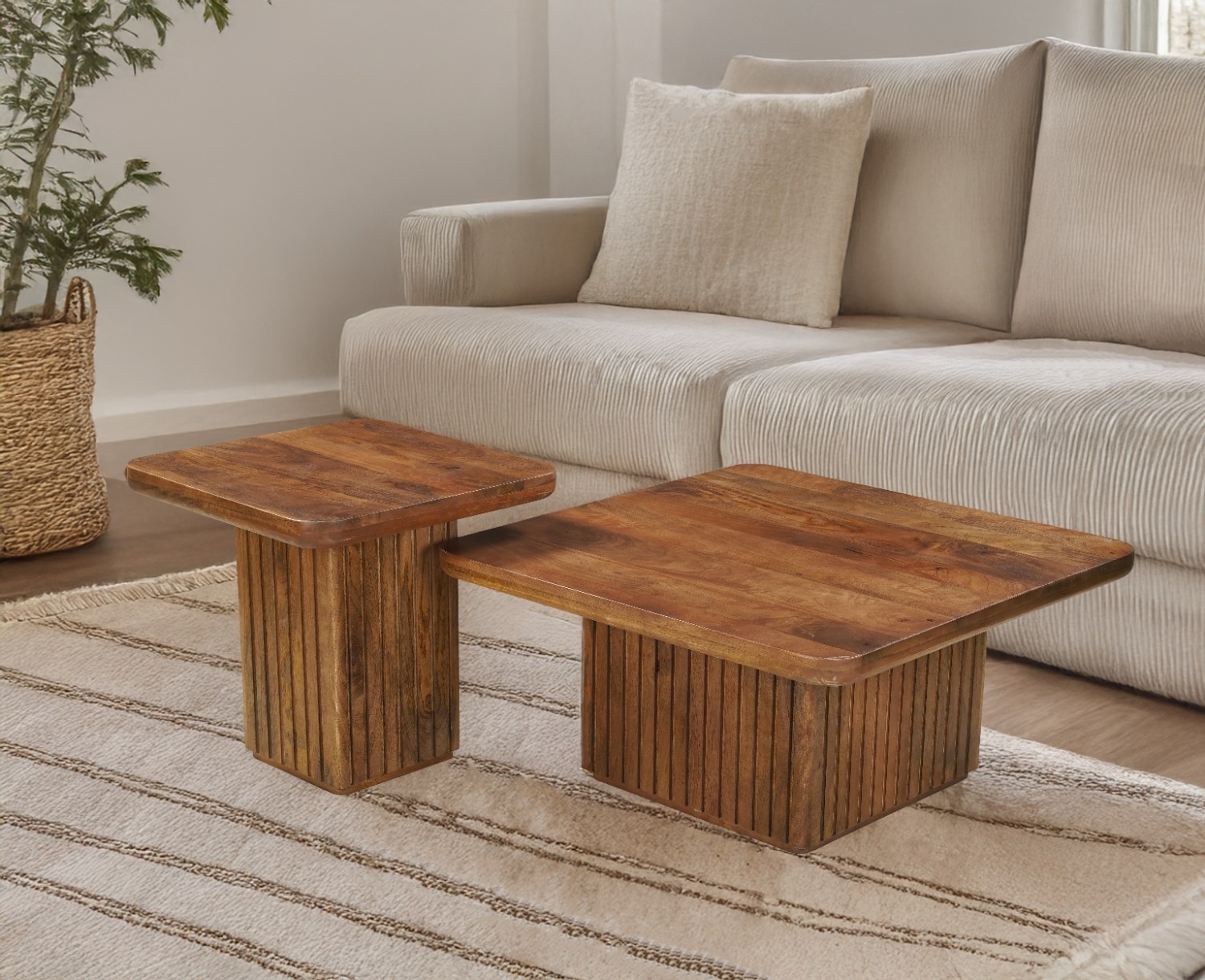 Two square wooden coffee tables with fluted bases and rich brown tops, styled in a cozy living room with a beige corduroy sofa and cream striped rug.