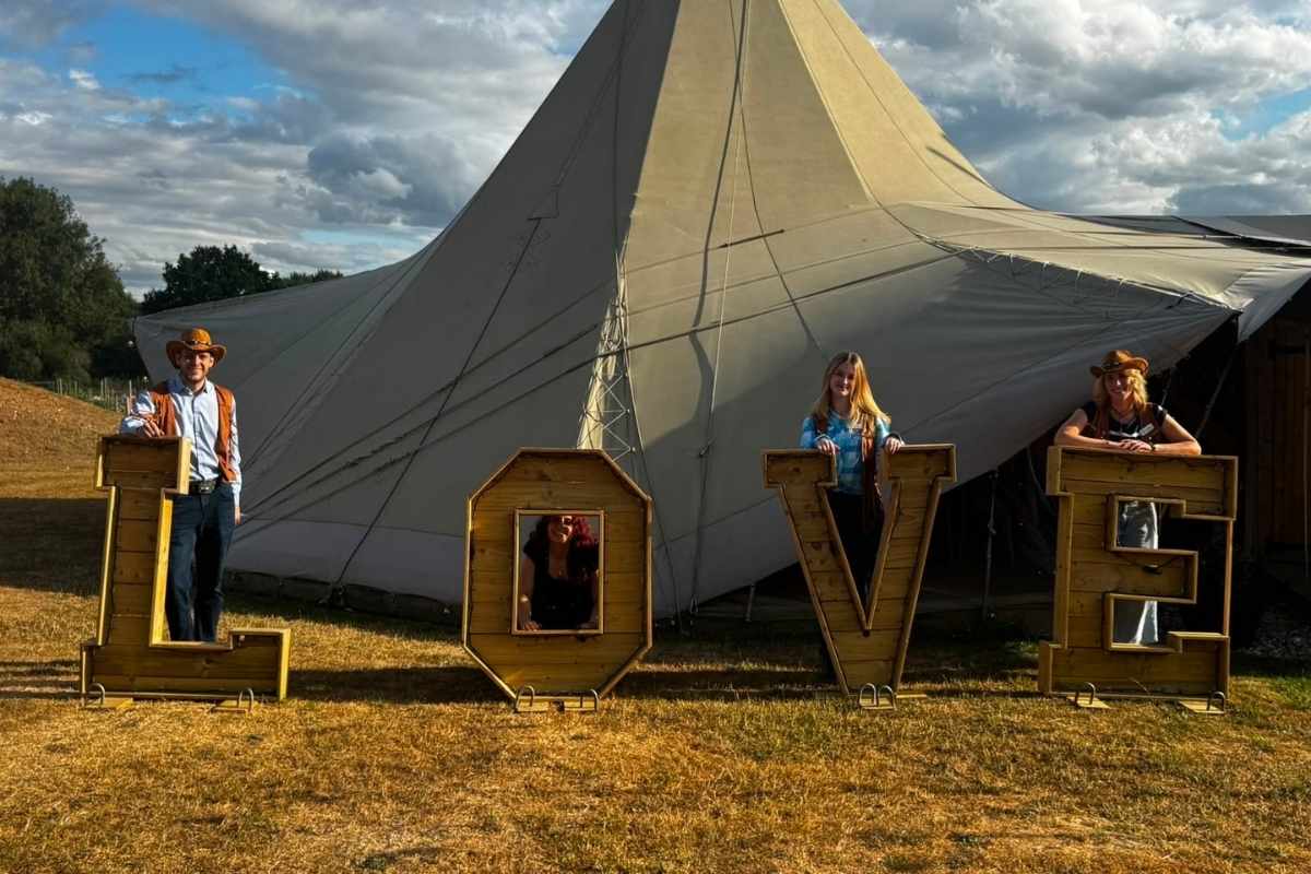 4 of Lucent's advisers at our summer bbq, each standing behind one letter of the word LOVE