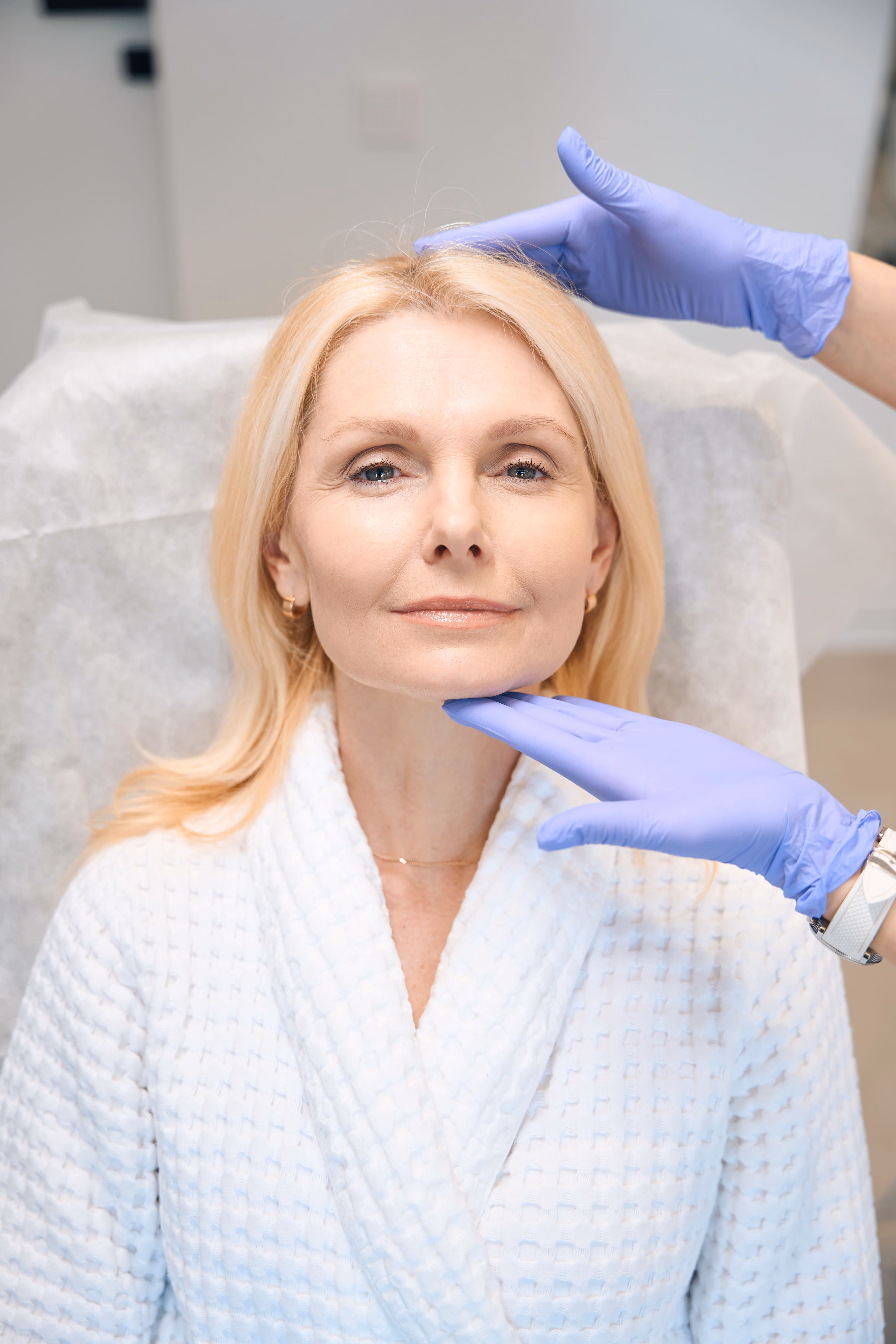 Schéma en coupe des couches du visage (peau, graisse, SMAS, ligaments) montrant la descente des tissus profonds avec l'âge