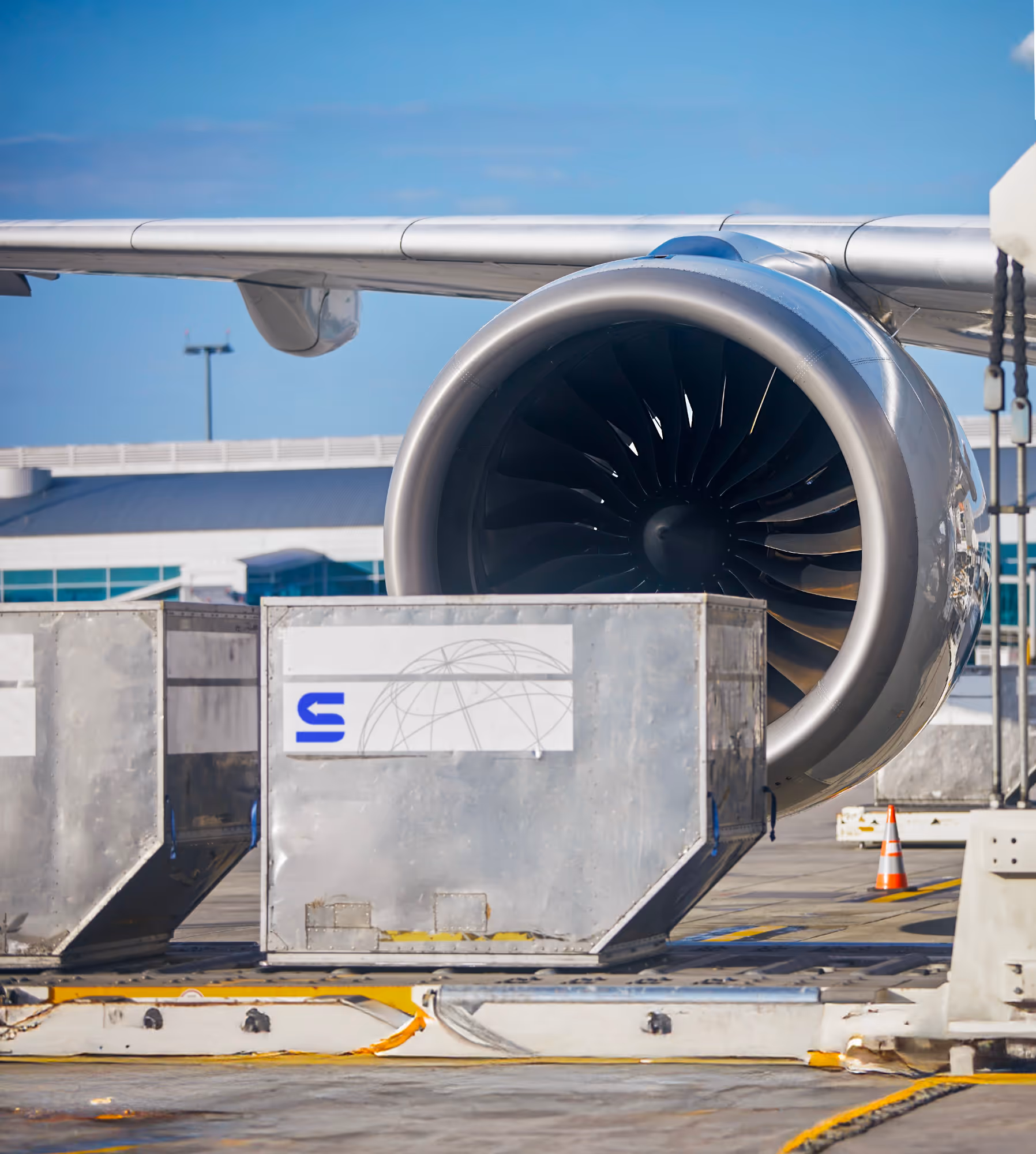 Servicio de flete aéreo profesional mostrando contenedores ULD durante el embarque en un aeropuerto.