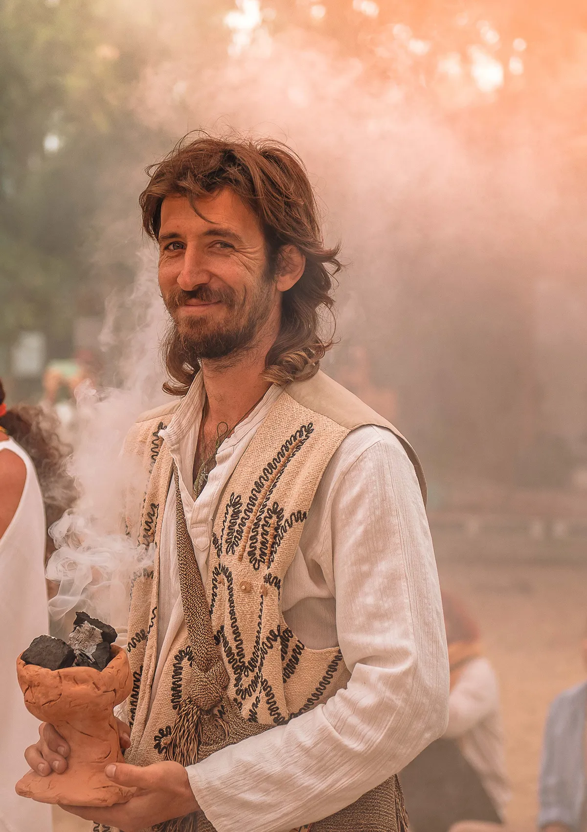 Tomás, Founder of Icaros Medicine Festival smiling, holding a fire copalera
