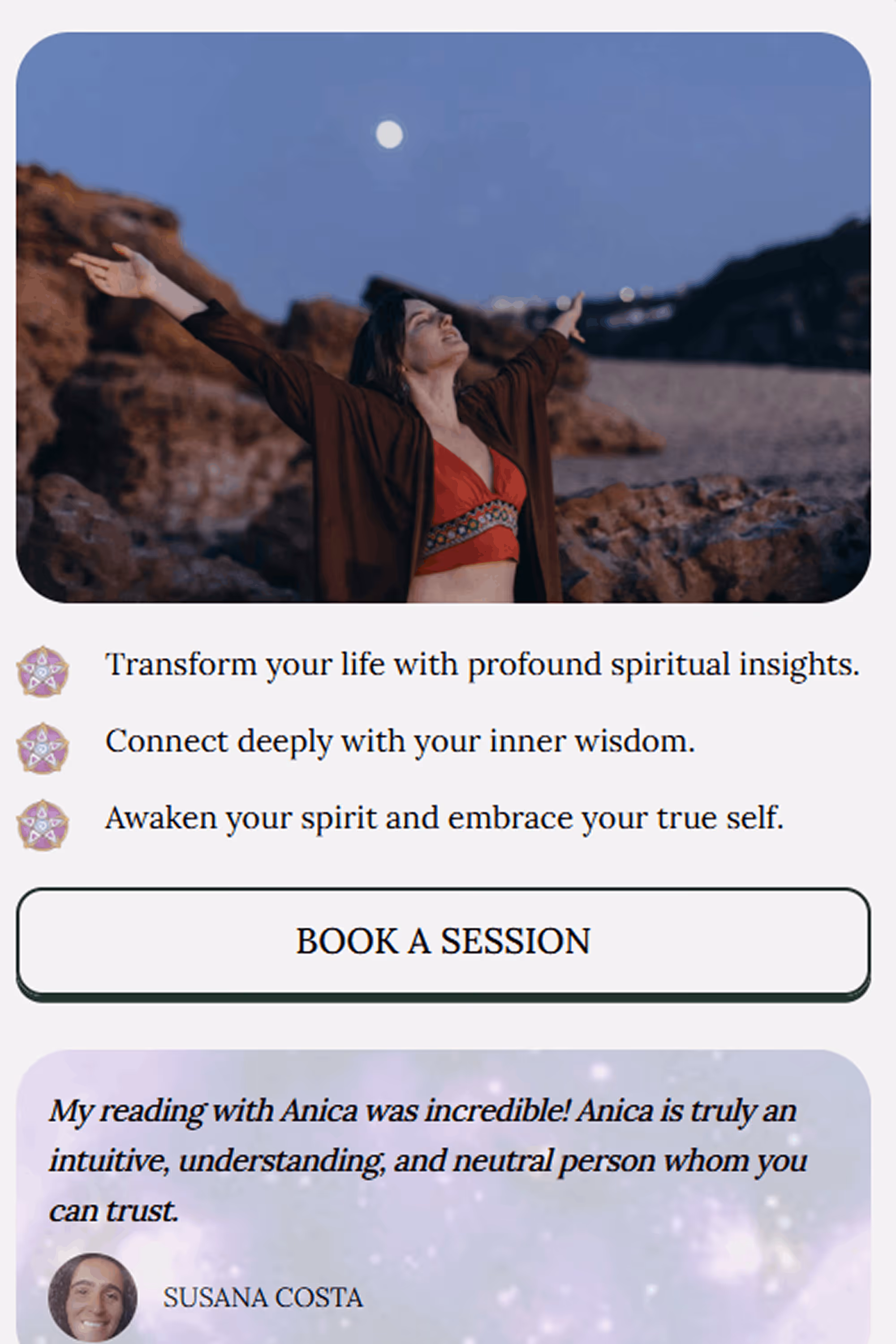 Person in red top and brown cardigan raising arms toward the moonlit sky over rocky terrain.