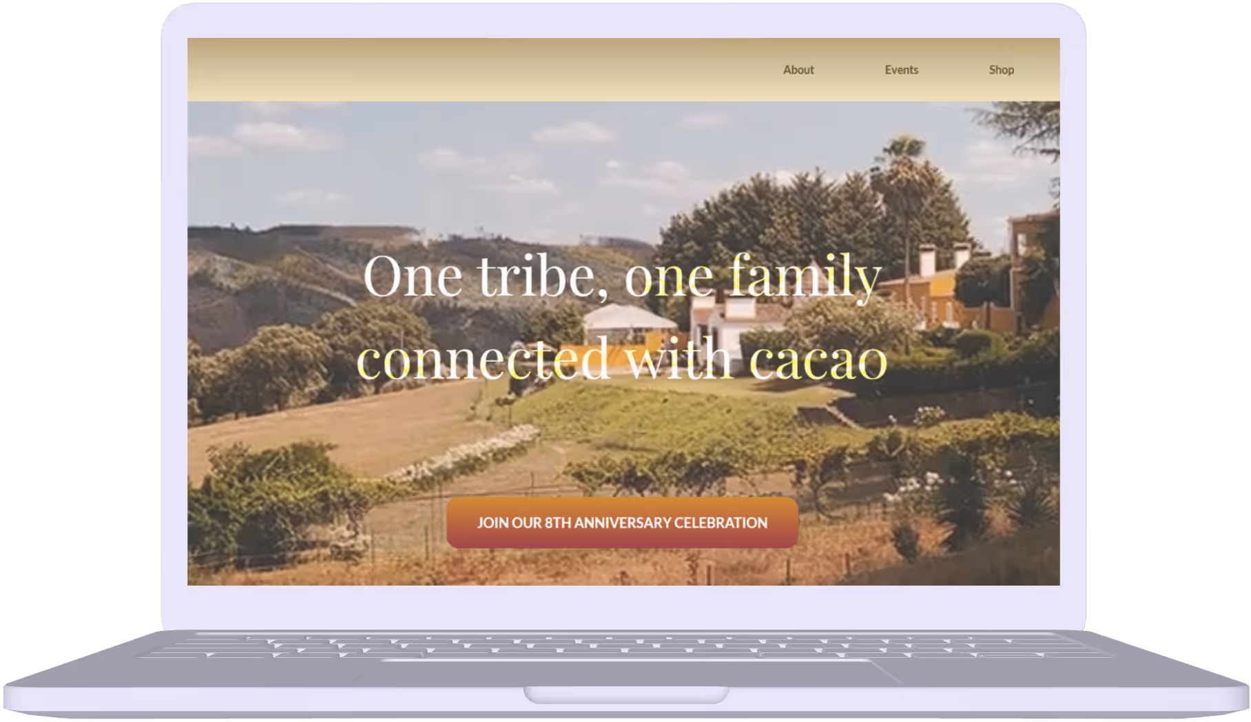 Laptop screen displaying a website with a rural landscape background and text reading 'One tribe, one family connected with cacao' and a button for an 8th anniversary celebration.