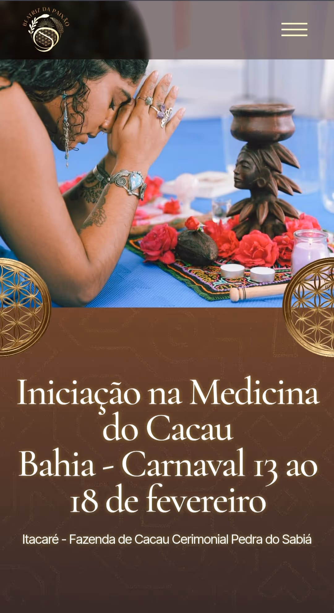 Woman with closed eyes and hands in prayer near an altar with red flowers, candles, and a wooden statue on a blue cloth.