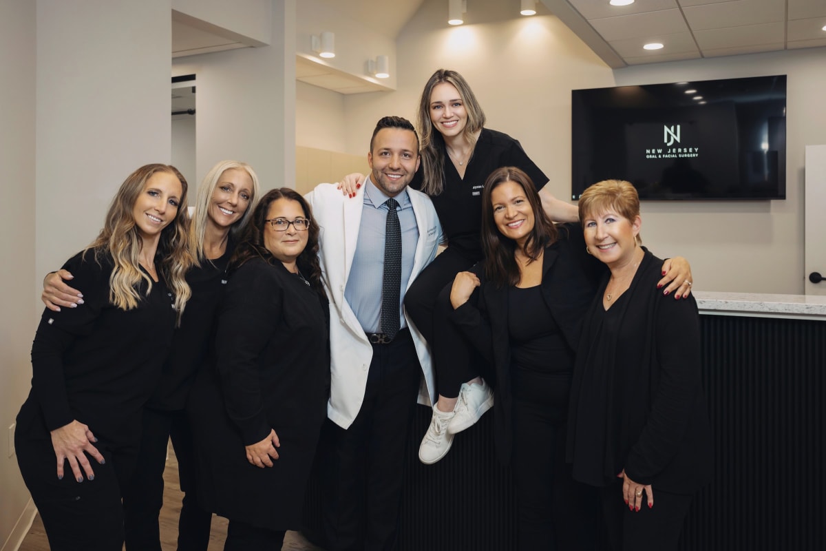 Professional dental team in business attire standing together in modern office setting