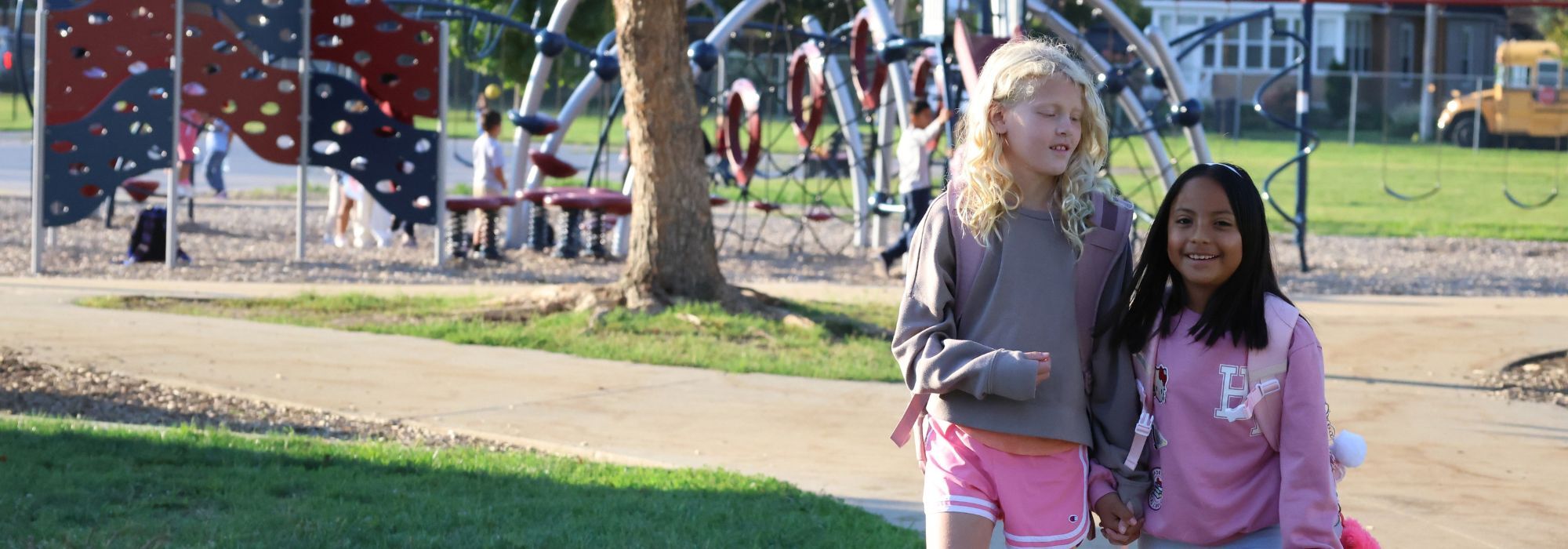 Two students walk past a playground in a photo from Jefferson Elementary's page on the Holland Public Schools website