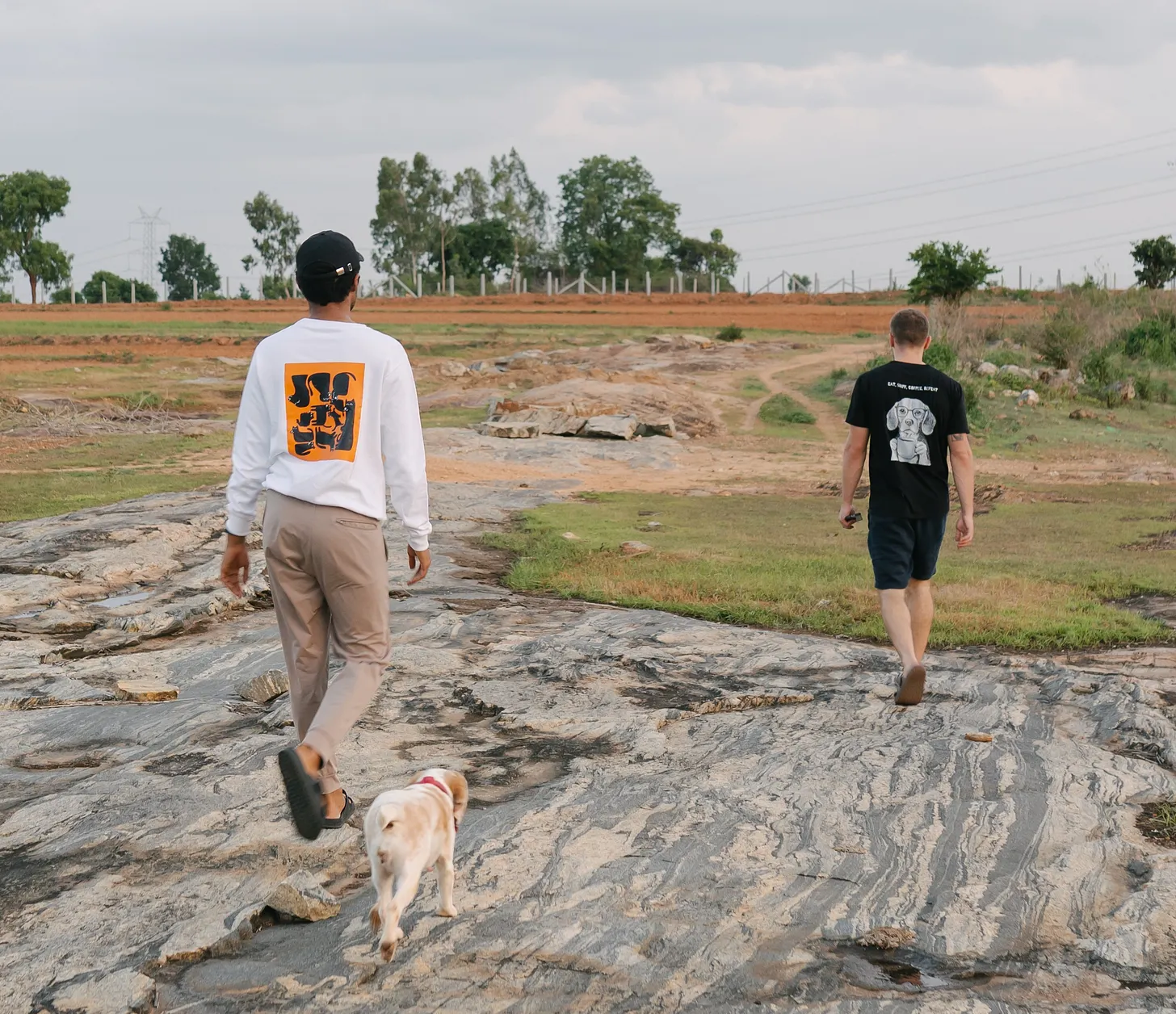Two members of the Dognosis team walking with a detection dog, both wearing Dognosis merch