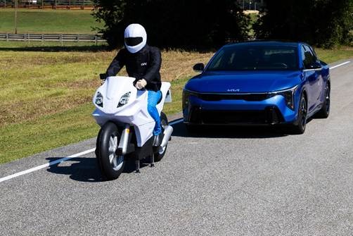 A person on a motorcycle next to a blue carAI-generated content may be incorrect.