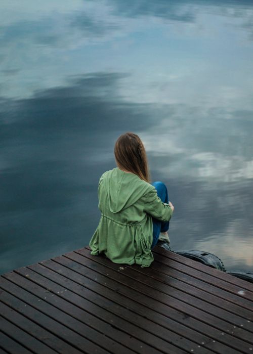 woman sitting by the lake