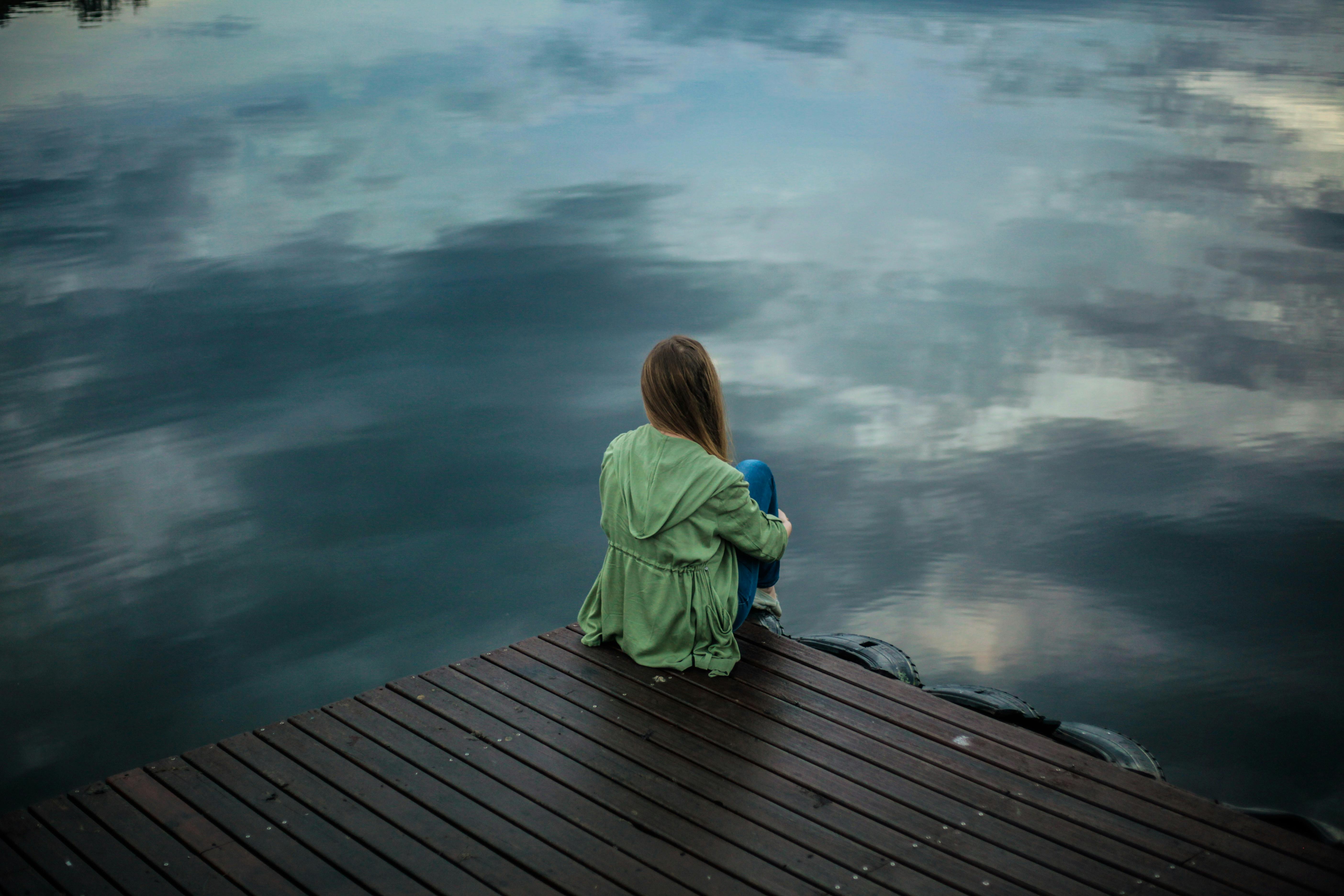 Person sitting alone, illustrating the loss of pleasure that defines anhedonia