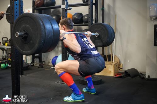 Zawodnik wykonujący przysiad z tyłu