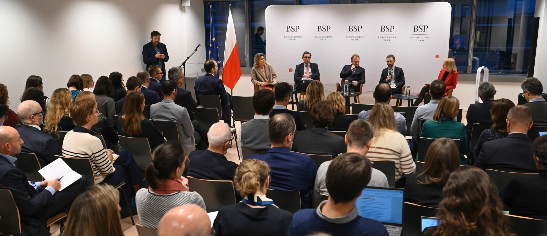 Panel discussion at a conference with an audience