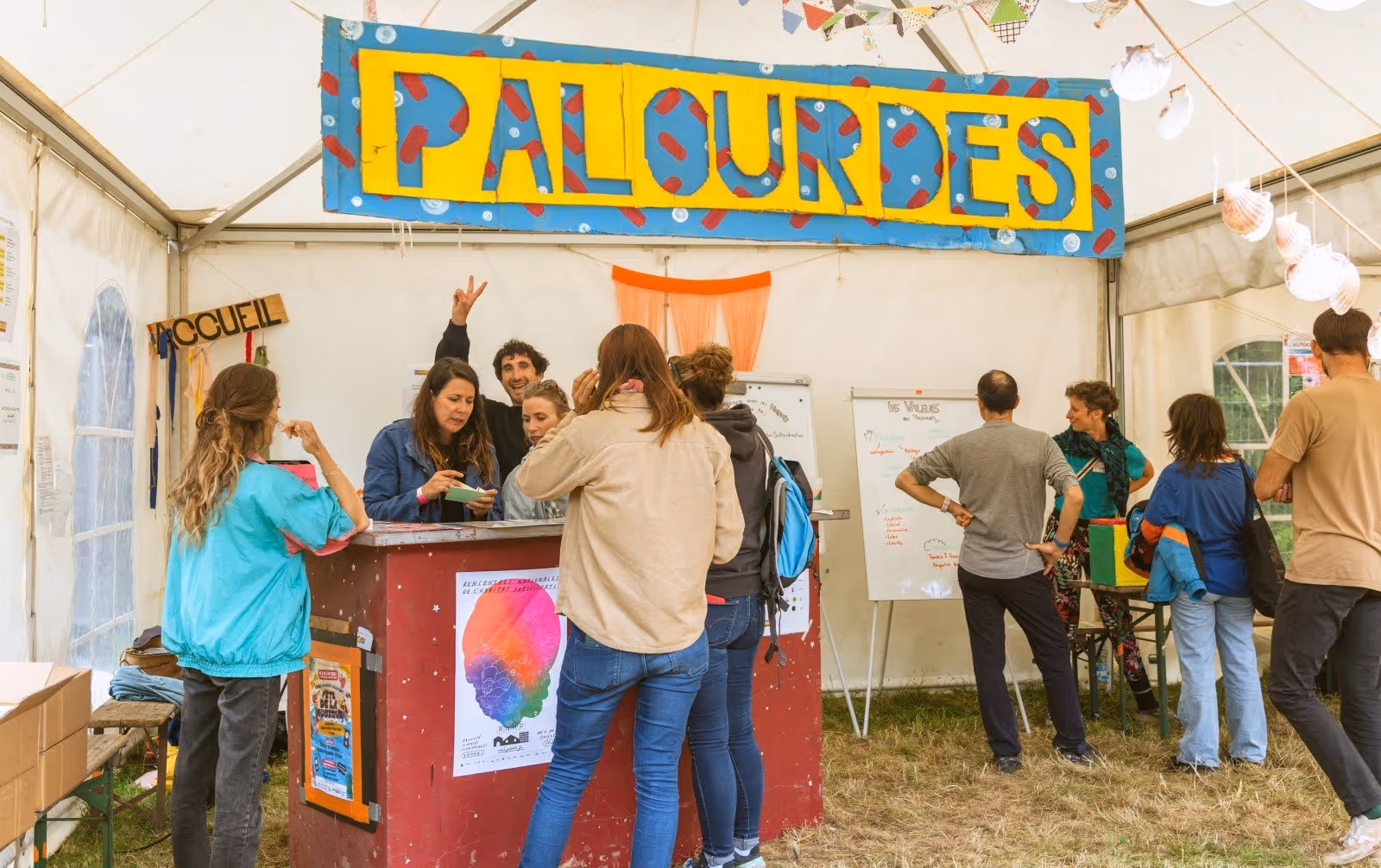 plusieurs personnes se renseignant Ă l'accueil du festival les palourdes