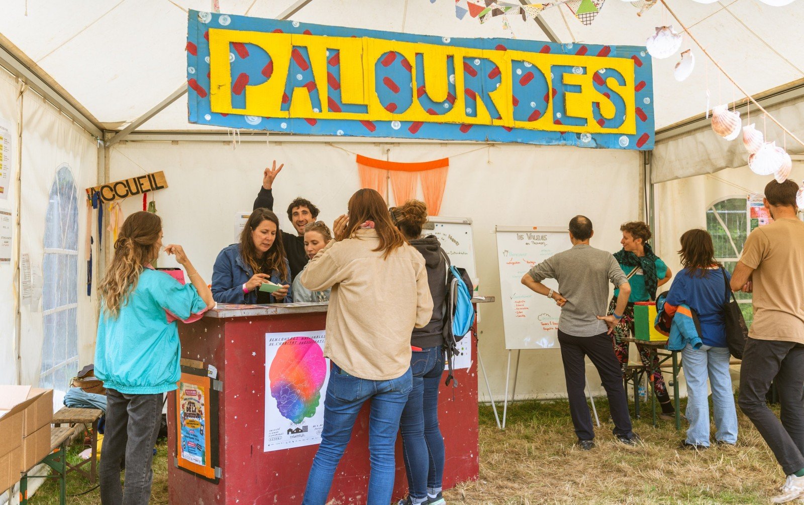 plusieurs personnes se renseignant à l'accueil du festival les palourdes