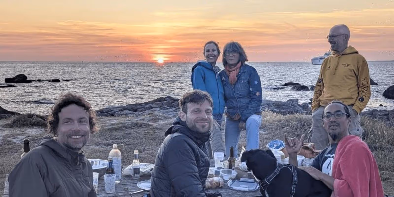 un groupe de personnes pendant un pique nique devant la mer