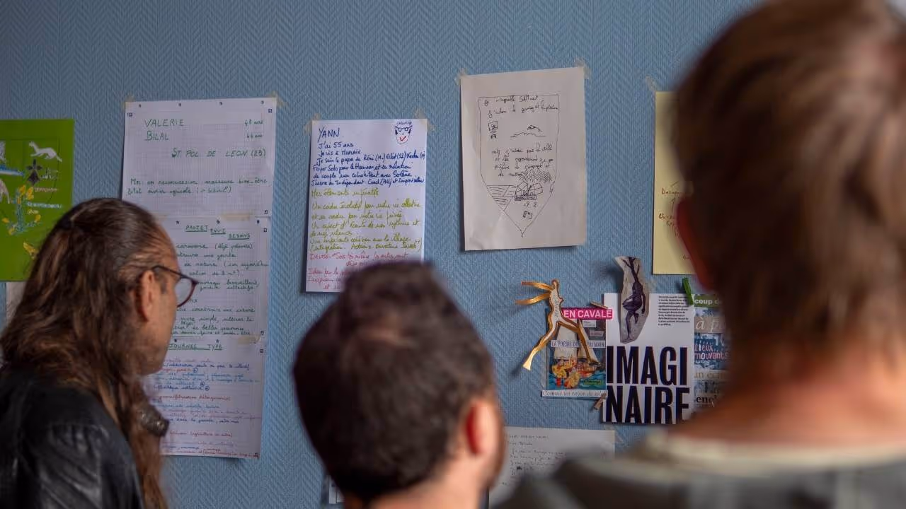 Participant·es qui consultent les blasons des personnes présentes lors d’un événement de rencontres pour un projet de hameau léger